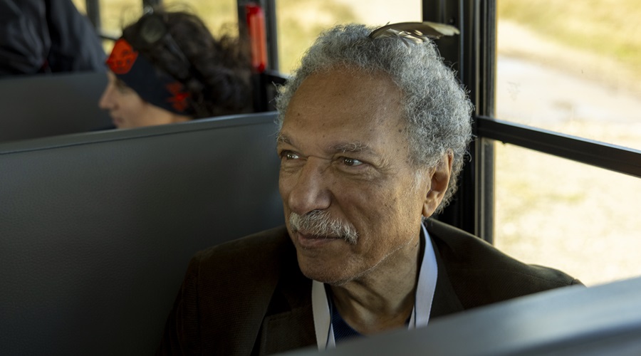 Daniel Pauly sitting on a bus and smiling.