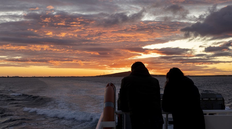 Two people watching the sunset from a boat in Miquelon.